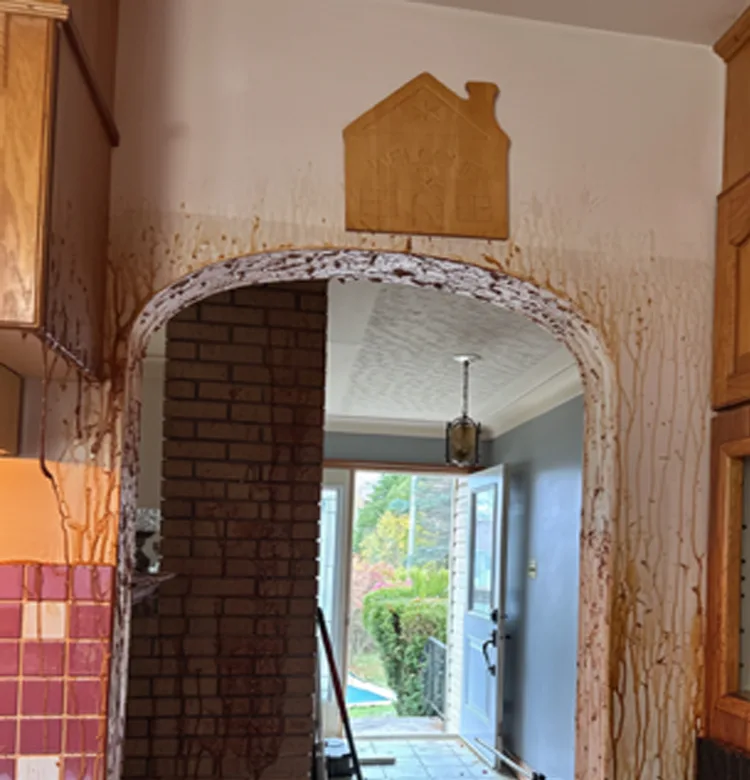 Before nicotine treatment, with brown residue staining the wall around a kitchen archway